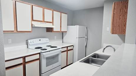 A white stove and oven in a kitchen with white cabinets.