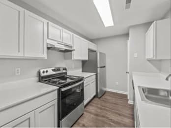 a kitchen with white cabinets and a stove and a sink