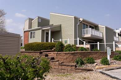 A building with a green and grey exterior and a balcony.