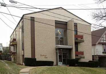 A two-story building with a brown door and windows.