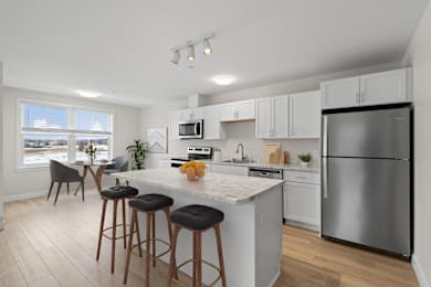 A kitchen with a white countertop and stainless steel appliances.