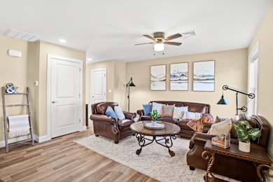 A living room with a brown leather couch and a white door.