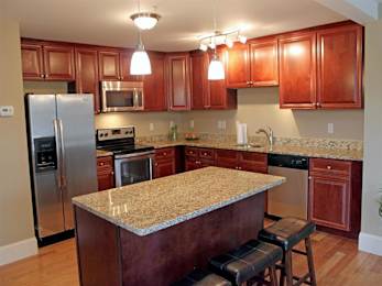 A kitchen with wooden cabinets and granite countertops.