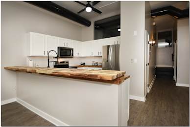 a kitchen with white cabinets and a wooden counter top
