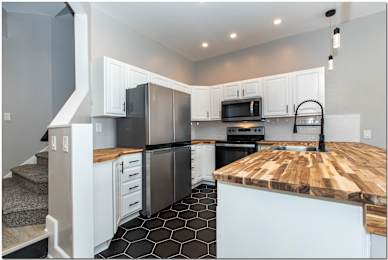 a kitchen with stainless steel appliances and a wooden counter top