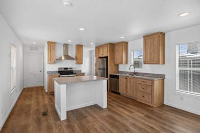 A kitchen with wooden cabinets and a white island.