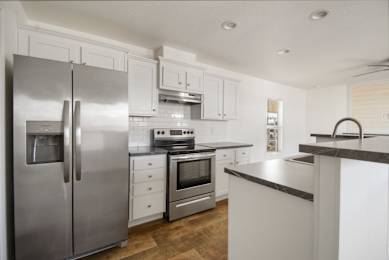 A modern kitchen with stainless steel appliances and white cabinetry.