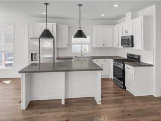 A kitchen with white cabinets and a black island.
