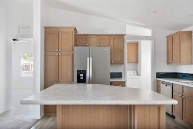 A kitchen with a refrigerator, oven, and microwave.