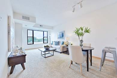 A living room with a white couch, a black coffee table, and a white chair.