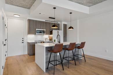 a kitchen with a large island with three bar stools