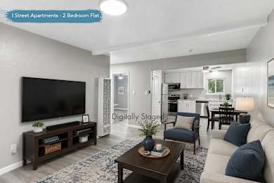 A living room with a flat screen TV and a coffee table.