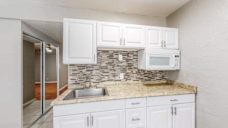 A kitchen with white cabinets at I Street Apartments, Davis, 95616
