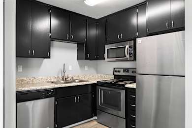 Kitchen with black cabinets at OSM Properties Homes & Apartments, California