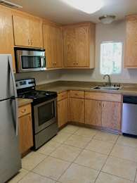 Kitchen with oak cabinets and beige tile flooring at OSM Properties Homes & Apartments, Chico, CA