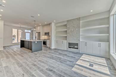 A spacious kitchen with a grey island and white cabinets.