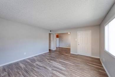 A room with wooden flooring and white walls.