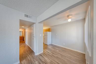 A room with a white wall and a wooden floor.