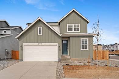A two-story house with a garage and a driveway.