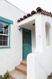 a white house with a green door and a window