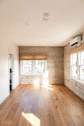 A room with wooden floors and a window with blinds.