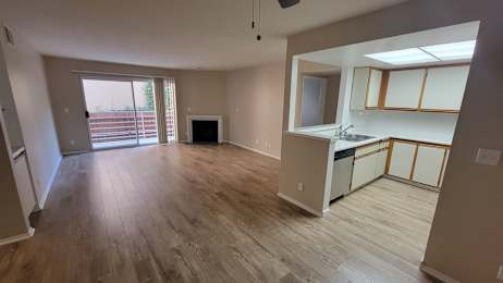 A kitchen area with a sink, cabinets, and a window.