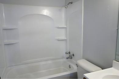 A white bathroom with a tub, toilet, and sink.