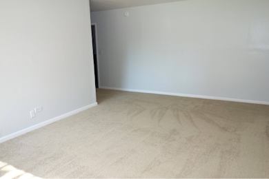 A room with a carpeted floor and white walls.