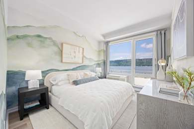 A bedroom with a large bed and a painting on the wall.