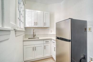 A kitchen with white cabinets and a black refrigerator at Clay & Tiffany, Portland, 97201