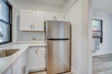 A kitchen with a stainless steel refrigerator and white cabinets at Clay & Tiffany, Portland, 97201