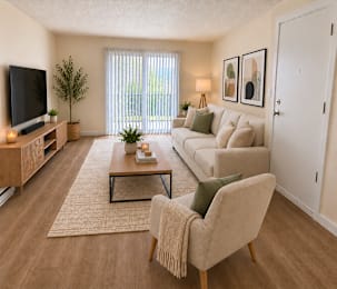 Living room with beige sofa and abstract wall art at Laurel on 2nd Apartments, Newberg, OR 97132