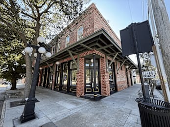 A brick building with a black lamp post in front.