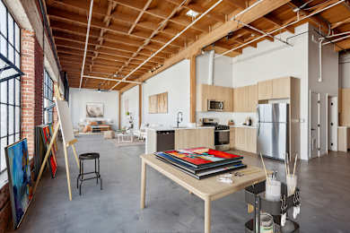 A room with a wooden ceiling and a table with a book on it.