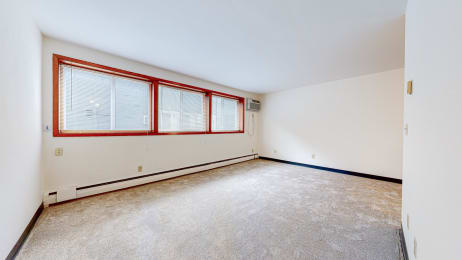 a bedroom with white walls and a large window