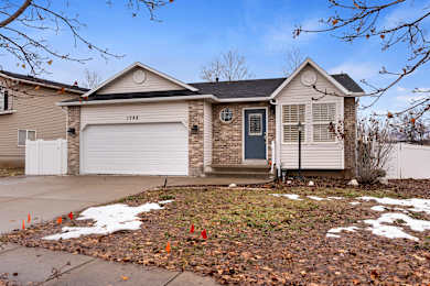 A house with a grey garage door and a black front door.