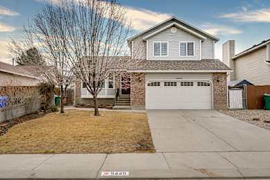 A house with a garage and a driveway in front of it.