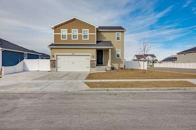 A two-story house with a garage is situated in a residential area.