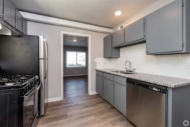 A kitchen with a stove top oven, dishwasher and a window. at Blacklark Apartments, Kansas, 66101