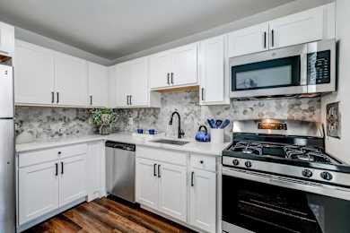 A kitchen with white cabinets and a black stove top.