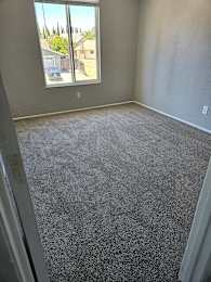a carpeted living room with a large window