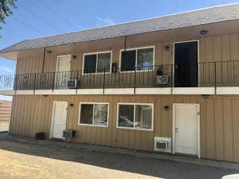 the front of a building with a balcony and two doors