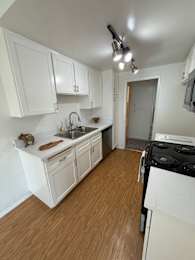 A kitchen with white cabinets and a black stove top oven.
