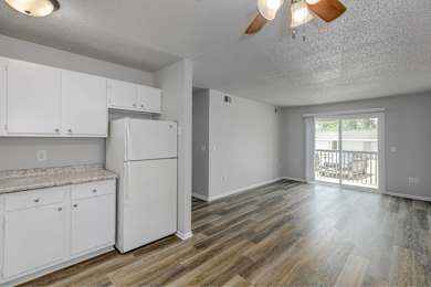 A kitchen with white cabinets and a refrigerator.at Fish Creek, Norwalk, IA 50211