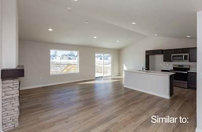 an empty living room with a kitchen and a fireplace at Two Rivers Home Rentals, West Des Moines, IA 50266
