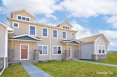 a beige house with a sidewalk in front of it at Two Rivers Home Rentals, West Des Moines, IA