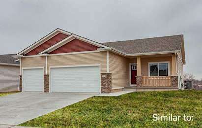 a beige house with a porch and a driveway at Two Rivers Home Rentals, West Des Moines, Iowa