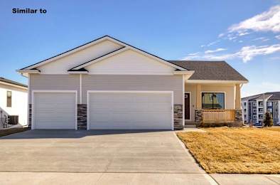 a white house with a white garage door at Two Rivers Home Rentals, Iowa 50266