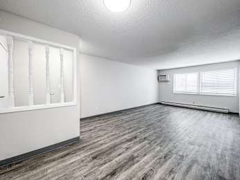 A room with wooden flooring and white walls at The Ridges Apartments, Iowa, 50315