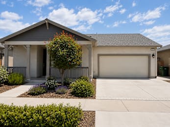 A house with a grey roof and a white garage door.